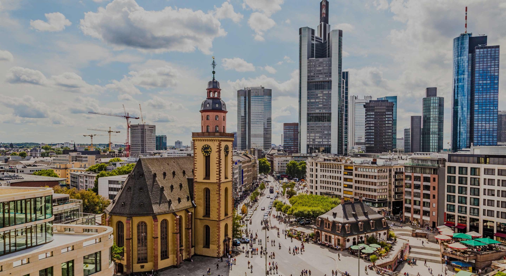 Blick auf eine belebte Stadt mit alten und modernen Hochhäusern unter blauem Himmel.