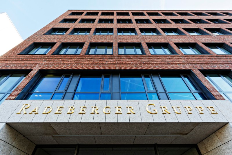 Mehrstöckiges Gebäude mit roten Ziegeln und großen Fenstern. Der Eingang trägt den Schriftzug Radeberger Gruppe in Gold.