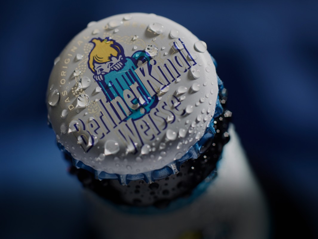 Nahaufnahme eines Flaschendeckels mit Wassertropfen, der ein charakteristisches Logo zeigt.