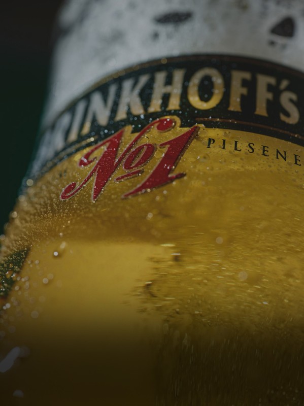 Nahaufnahme eines Bierglases mit kondensierender Feuchtigkeit und sichtbaren Bläschen.