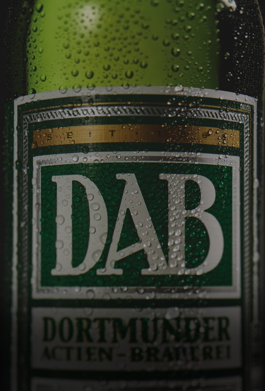 Nahaufnahme einer Bierflasche mit Wassertropfen auf dem Etikett.