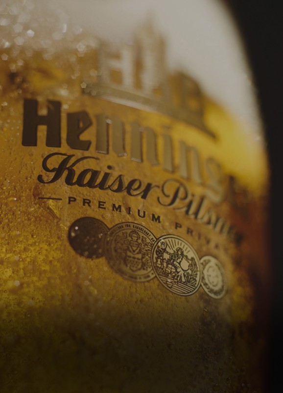 Nahaufnahme eines goldenen Etiketts mit Prägung und Kondensationstropfen.