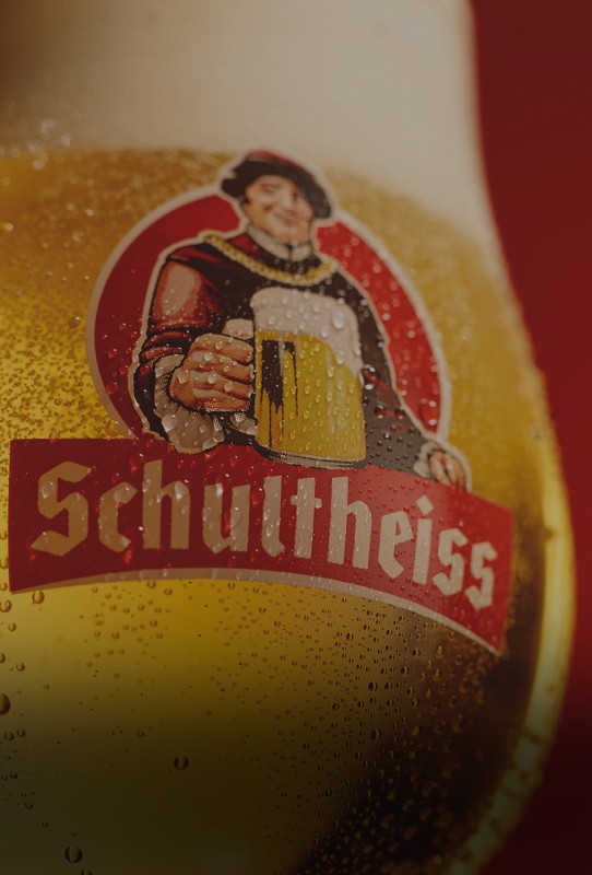Auf dem Foto ist eine Grafik eines lachenden Mannes mit Bierkrug auf einem Getränkeetikett zu sehen.