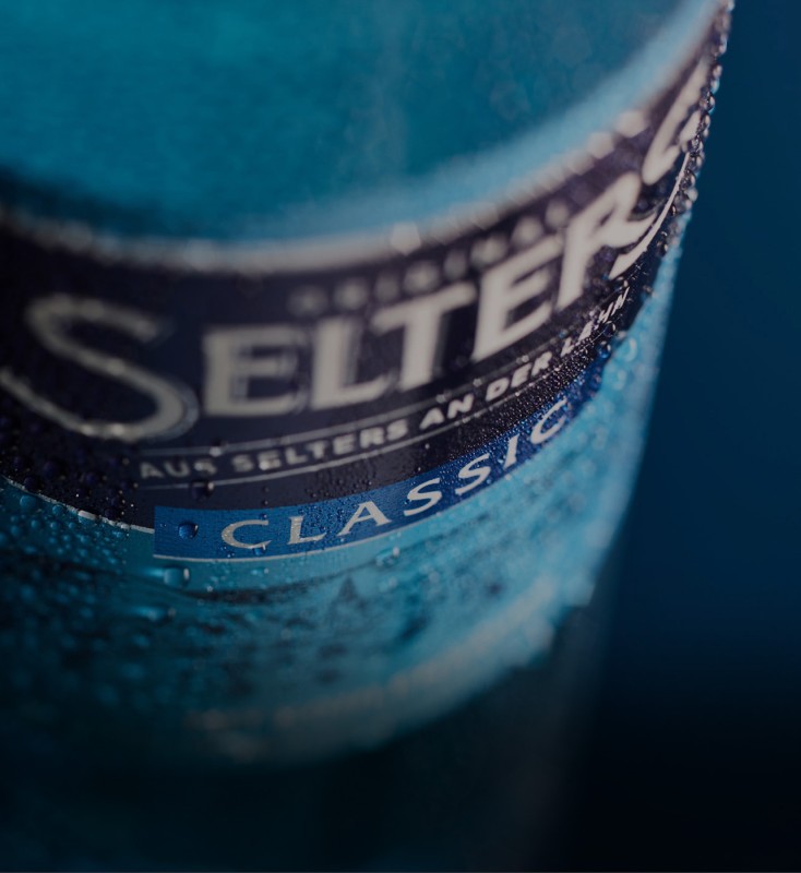 Nahaufnahme einer blauen Flasche mit Kondenswasser und dem Wort Classic.